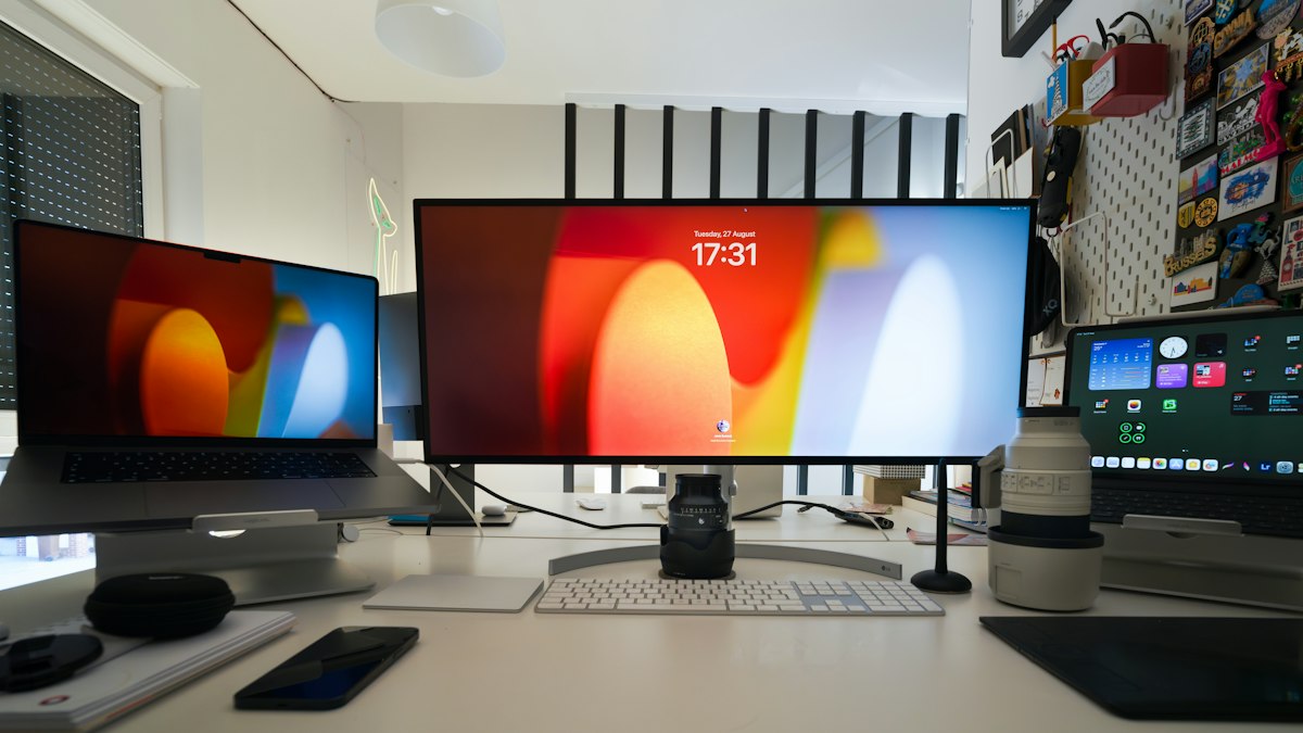 Three computer monitors sitting on top of a desk